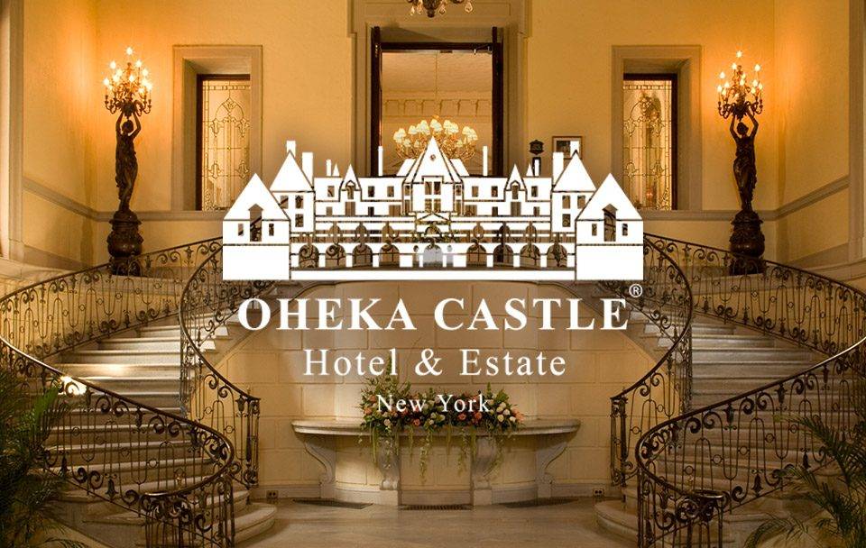 Interior view of Oheka Castle showcasing grand staircase and elegant chandeliers.