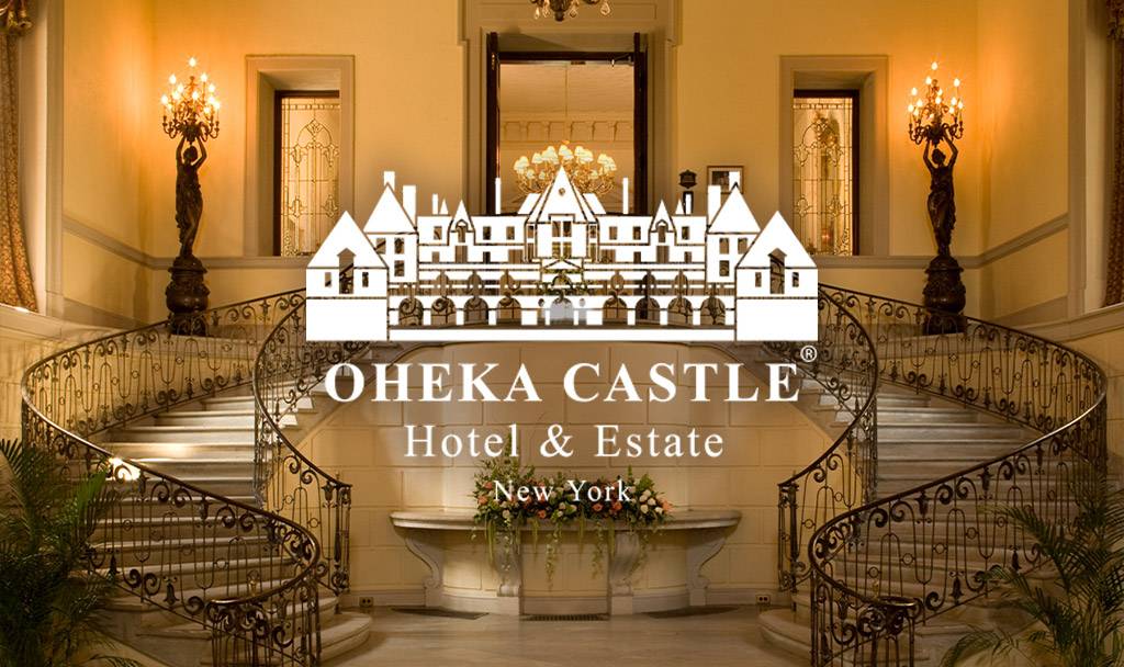 Interior view of Oheka Castle showcasing grand staircase and elegant chandeliers.