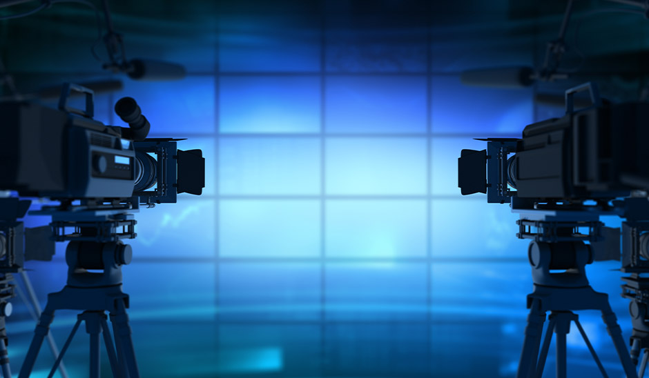 Two professional video cameras set up on tripods in a studio environment with a blue gradient background.