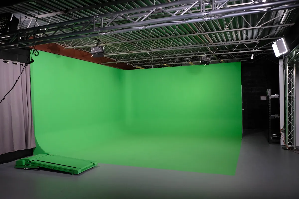 Green Screen | Idea Stream Marketing A green screen studio setup with a seamless green backdrop and studio lights.