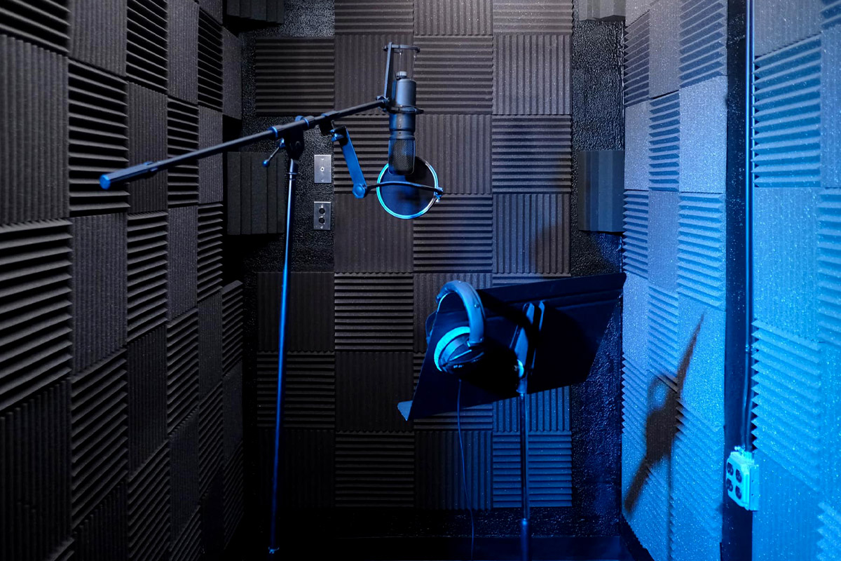 Sounds-Room | Idea Stream Marketing A close-up view of a soundproof recording booth featuring a microphone and headphones.