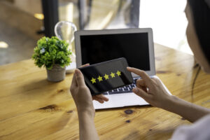 Businesswoman Rating Service on Phone | Idea Stream Marketing Customer leaving a 5-star review for a local business