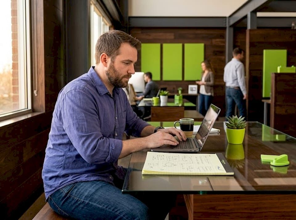 Business owner focused on setting up Google Ads on a laptop in a modern workspace.