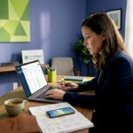 Businesswoman analyzing CRM software on a laptop in a modern office setting.