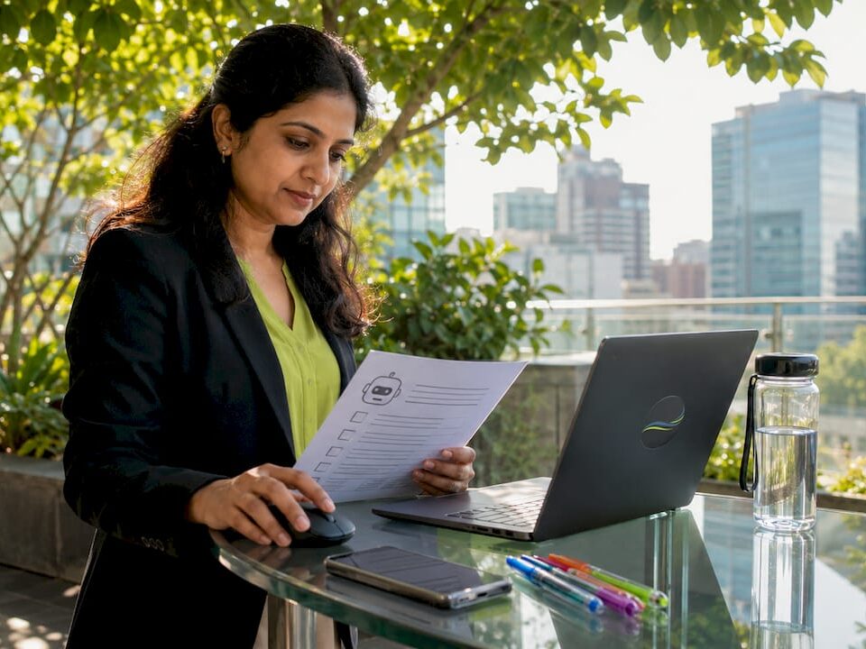 Business analyst reviewing documents on a tablet outdoors with city skyline in the background.