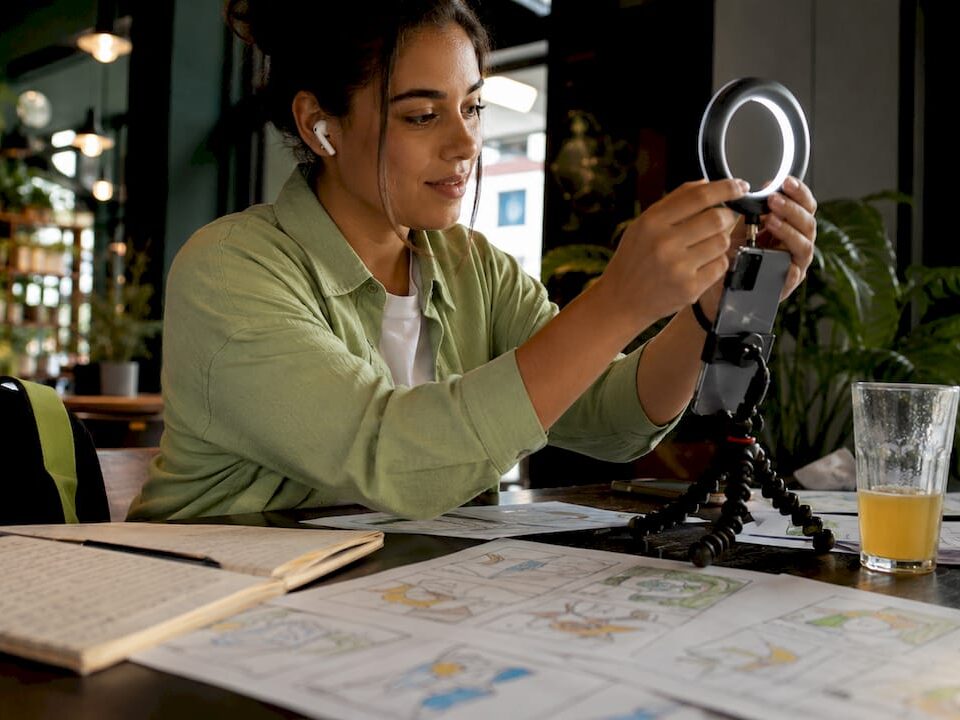 Content creator adjusting smartphone on tripod with ring light for filming Reels.