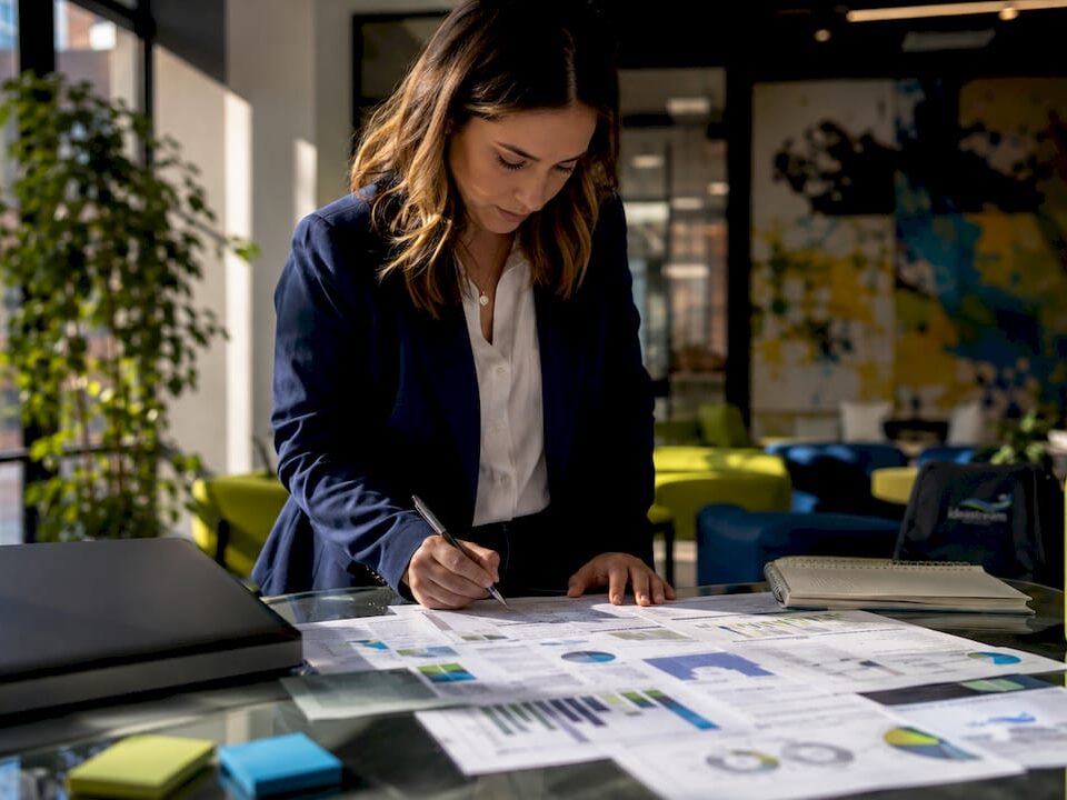 Healthcare marketer reviewing patient acquisition reports at a table with graphs and charts.