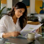 Woman reviewing a content strategy document at a glass table with plants around.