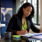 A marketing manager reviewing branding strategy documents at a modern office desk.