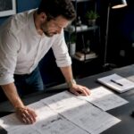 Man reviewing storyboards for a video production project on a desk.